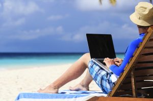 man with laptop on tropical vacation
